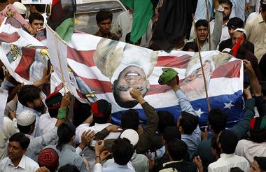 Pakistanische Demonstranten schlagen symbolisch auf ein Transpar... Pakistanische Demonstranten schlagen symbolisch auf ein Transpar...