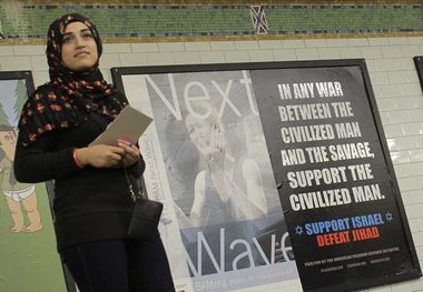 Muslima vor einem Plakat der rechten American Freedom Defense In... Muslima vor einem Plakat der rechten American Freedom Defense In...
