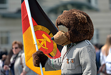 Mit Fahne, Uniform und Bärenkostüm posiert ein Statist in Berlin...
