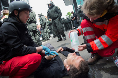 Sanit&auml;ter versorgen einen von der Polizei verletzten Journa...