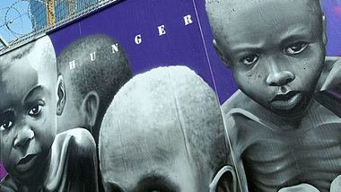 Hunger wird gemacht: Graffiti am Bauzaun des Neubaus der Europ&a