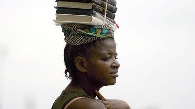 Eine angolanische Buchver- käuferin bei der Arbeit in Luanda.