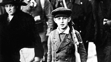 1. August 1914: Ein Junge bringt den Koffer und das Gewehr seine...