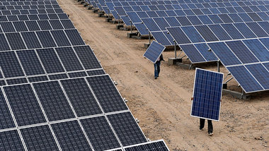 Große Flächen: Arbeiter bei der Montage von Solarpane... Große Flächen: Arbeiter bei der Montage von Solarpane...