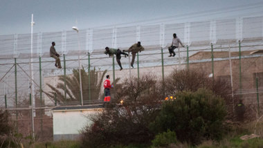 Fl&uuml;chtlinge &uuml;berklettern am Montag den schwer bewachte...