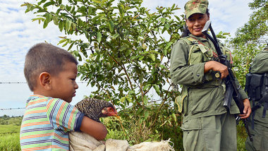 Ein Junge und eine FARC-Kämpferin am Zugang zu San Isidrio in de...