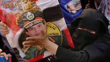 Eine Unterstützerin von Al-Sisi mit einem Bild des Exmilit&... Eine Unterstützerin von Al-Sisi mit einem Bild des Exmilit&...