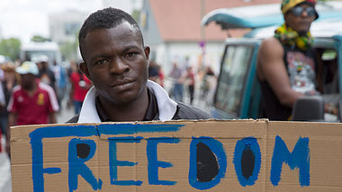 Demonstrant macht Anfang Juni in Berlin auf die verheerende Lebe... Demonstrant macht Anfang Juni in Berlin auf die verheerende Lebe...