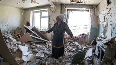 Eine Frau in Kramatorsk zeigt die Wohnung ihres Nachbarn, der be...
