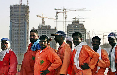 Bauarbeiter aus Indien und Pakistan warten in Dubai auf den Bus,...