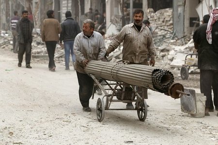 Bewohner von Aleppo schieben einen Karren mit Baumaterial an dur... Bewohner von Aleppo schieben einen Karren mit Baumaterial an dur...