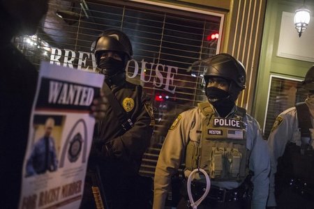 Mit einem Bild des Todesschützen Darren Wilson laufen Demonstran... Mit einem Bild des Todesschützen Darren Wilson laufen Demonstran...