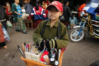 Ein junger Handverkäufer auf einem Markt in Laos