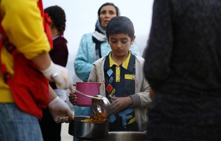 Ein Flüchtlingskind aus Kobane wartet geduldig auf seine Milchzu... Ein Flüchtlingskind aus Kobane wartet geduldig auf seine Milchzu...