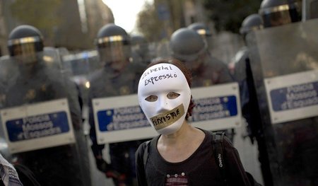 Eine maskierte Demonstrantin vor einer Polizeieinheit am Samstag... Eine maskierte Demonstrantin vor einer Polizeieinheit am Samstag...