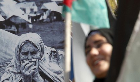 Eine Palästinenserin am 66. Jahrestag der »Nakba« vor einem Bild...