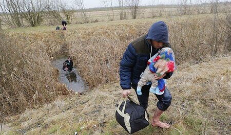 Ein Kosovare mit Baby beim Überwinden der Grenze von Serbien nac... Ein Kosovare mit Baby beim Überwinden der Grenze von Serbien nac...