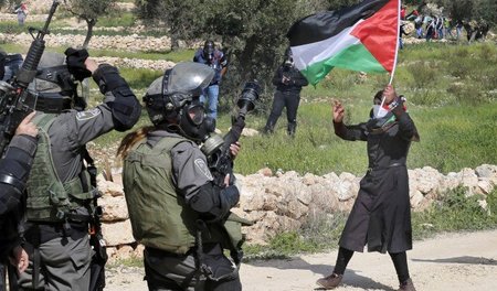 Eine Palästinenserin vor israelischen Soldaten während eines Pro...