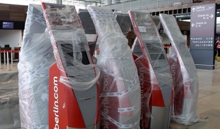 Warten auf Godot: Check-In-Terminals unter Schutzverpackung am z...