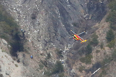 Ein Hubschrauber über der mit Trümmern übersäten Absturzstelle Ein Hubschrauber über der mit Trümmern übersäten Absturzstelle