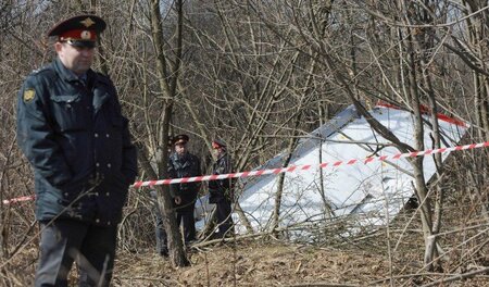 Unter Bewachung: Russische Polizisten am Wrack der abgestützten ...