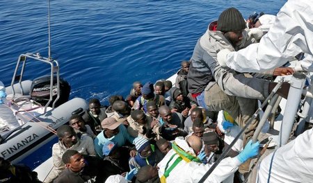 Angehörige einer italienischen Zolleinheit retten Flüchtlinge vo...