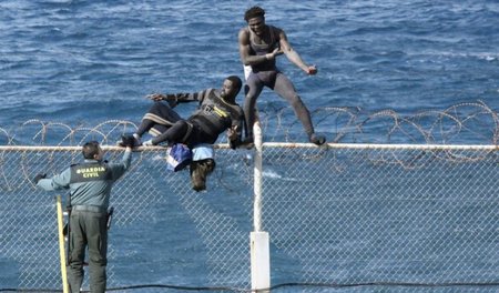 Flüchtlinge versuchen am 3. Februar, den Grenzzaun um Ceuta zu ü...