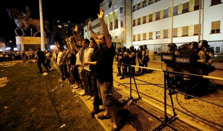 Demonstranten stehen am Mittwoch abend vor dem Parlament in Skop...