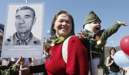 Fotos sowjetischer Weltkriegssoldaten werden beim »Marsch des un...