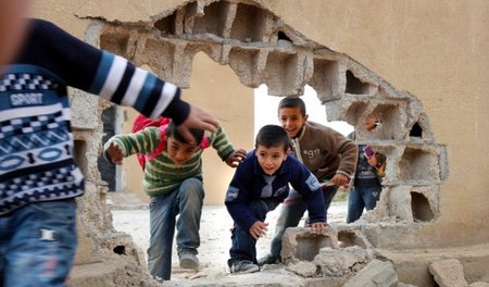 Kein Abenteuerspielplatz: Kinder spielen Fangen im kriegszerstör...