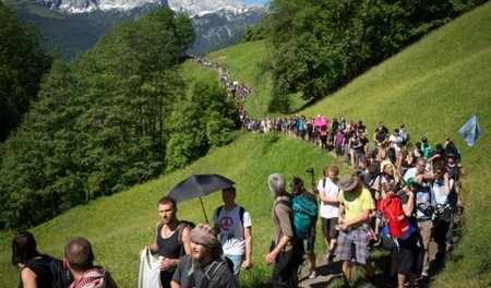 Sternmarschteilnehmer auf dem Weg zum Zaun um Schloss Elmau