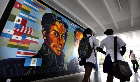 Studenten der ELAM in Havanna vor einem Bild des südamerikanisch...