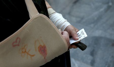 Schlagestehen für die karge Rente: Eine Pensionärin wartet vor e...
