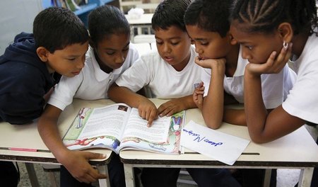 Caracas, 23. Mai 2014: Schulkinder mit einem neuen Lehrbuch. Im ...