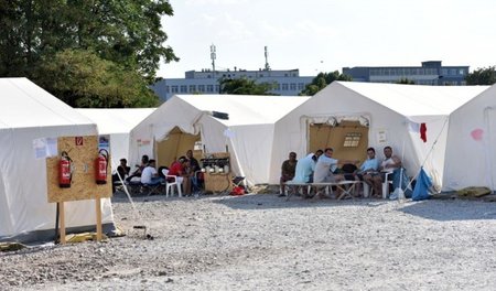 Flüchtlinge suchen bei brütender Hitze Schatten im Zeltlager in ...