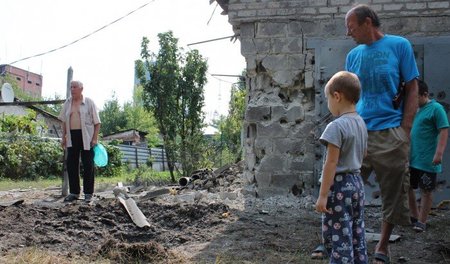 Einwohner von Donezk betrachten ein in ihrer Nähe eingeschlagene... Einwohner von Donezk betrachten ein in ihrer Nähe eingeschlagene...