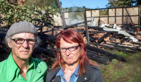 Birgit und Horst Lohmeyer vor den Trümmern ihrer ausgebrannten S...