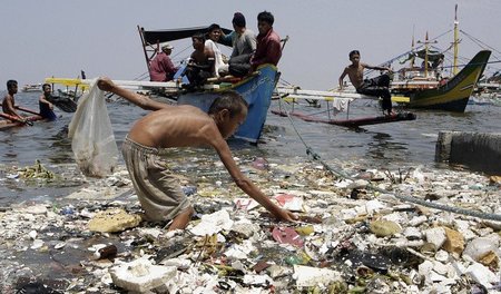 Ein Junge sammelt Plastik an der Küste der philippinischen Haupt...