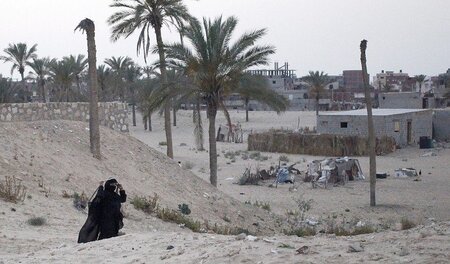 Menschenleeres Dorf: Eine Frau nahe einer verlassenen Ortschaft ...