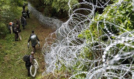 Ungarische Soldaten beim Bau des Stacheldrahtzauns an der Grenze...