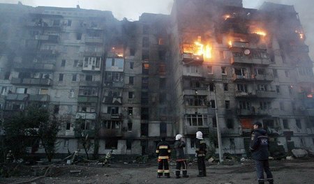 Donezk am Samstag: Feuerwehrleute und freiwillige Helfer löschen...