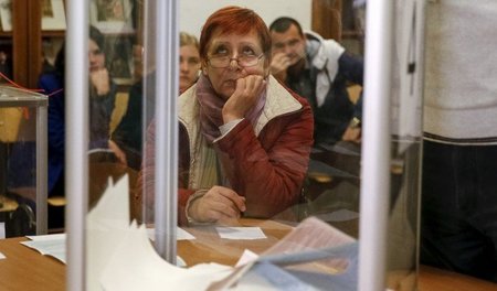 Warten auf die Ergebnisse: Eine Frau wartet am Sonntag in Kiew a... Warten auf die Ergebnisse: Eine Frau wartet am Sonntag in Kiew a...