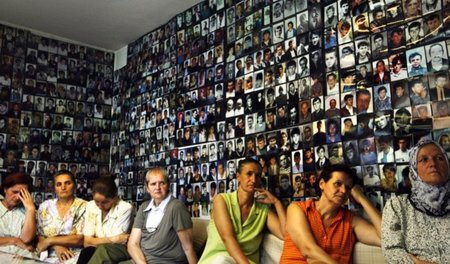 Muslimische Bosnierinnen vor Bildern in Srebrenica getöteter Män...