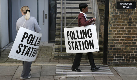 Wahlaufruf: Mitarbeiter eines Abstimmungslokals werben in Isling...