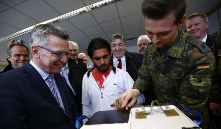 Innenminister Thomas de Maizière lässt sich von der erkennungsdi... Innenminister Thomas de Maizière lässt sich von der erkennungsdi...