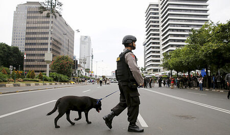 Ein Polizist patrouilliert mit Hund am Donnerstag nach den Ansch...