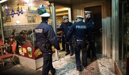 Polizeibeamte vor einem Café in Düsseldorf-Oberbilk während der ... Polizeibeamte vor einem Café in Düsseldorf-Oberbilk während der ...