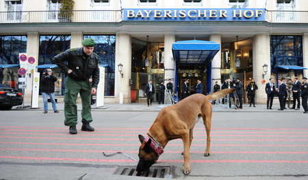 Such die Bombe, Bello! Polizist untersucht mit Spürhund vor Begi... Such die Bombe, Bello! Polizist untersucht mit Spürhund vor Begi...