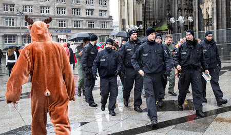 Karnevalsszene vor dem Kölner Dom: Ein Passant blickt verwundert...