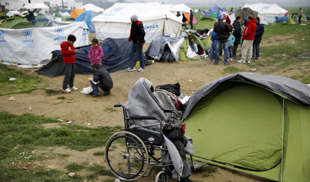 Flüchtlinge warten am Mittwoch in einem provisorischen Lager bei...